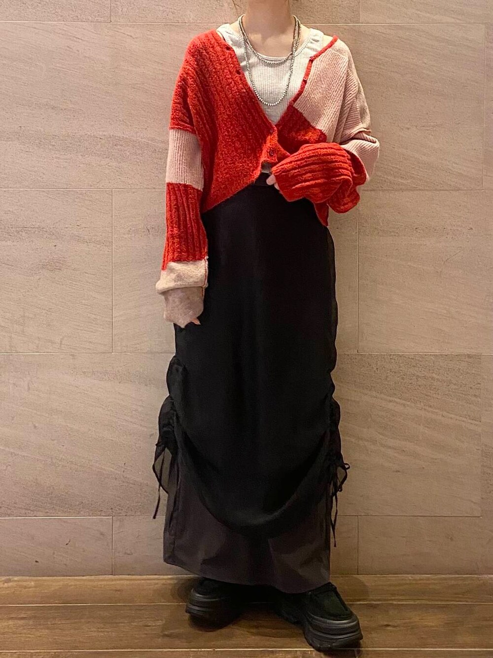 ブラック系のスカート、ブラック系のスニーカー、ベージュ系のタンクトップを着用したレディースの夏コーディネートの7枚目の写真