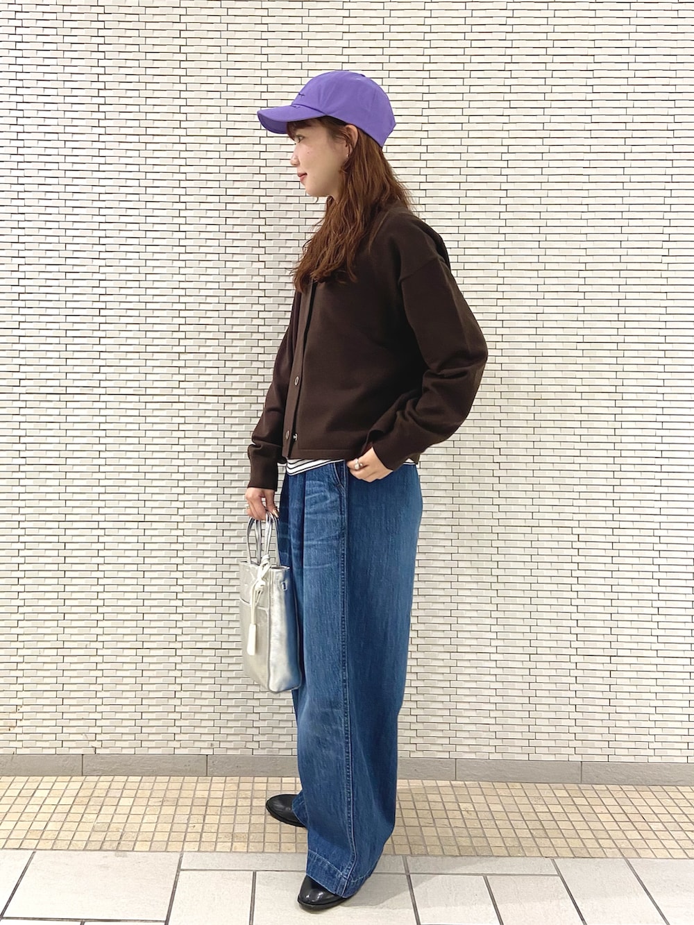 ブラウン系のカーディガン/ボレロ、ホワイト系のTシャツ/カットソー、シルバー系のトートバッグを着用したレディースの秋コーディネートの2枚目の写真