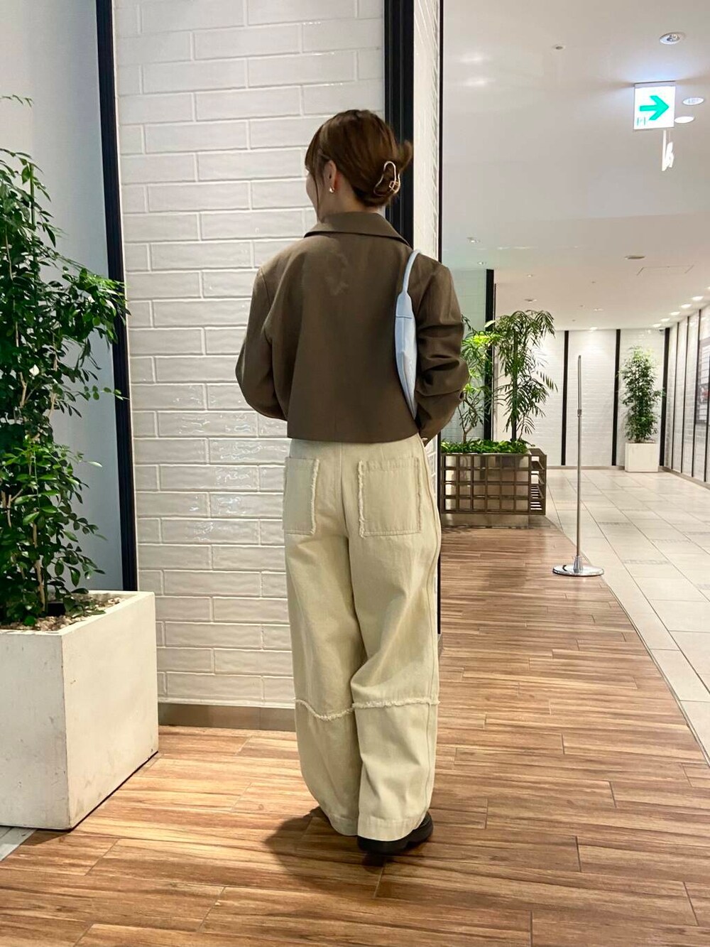 ブルー系のショルダーバッグ、ブラウン系のローファー、ホワイト系のその他パンツを着用したレディースの秋コーディネートの4枚目の写真