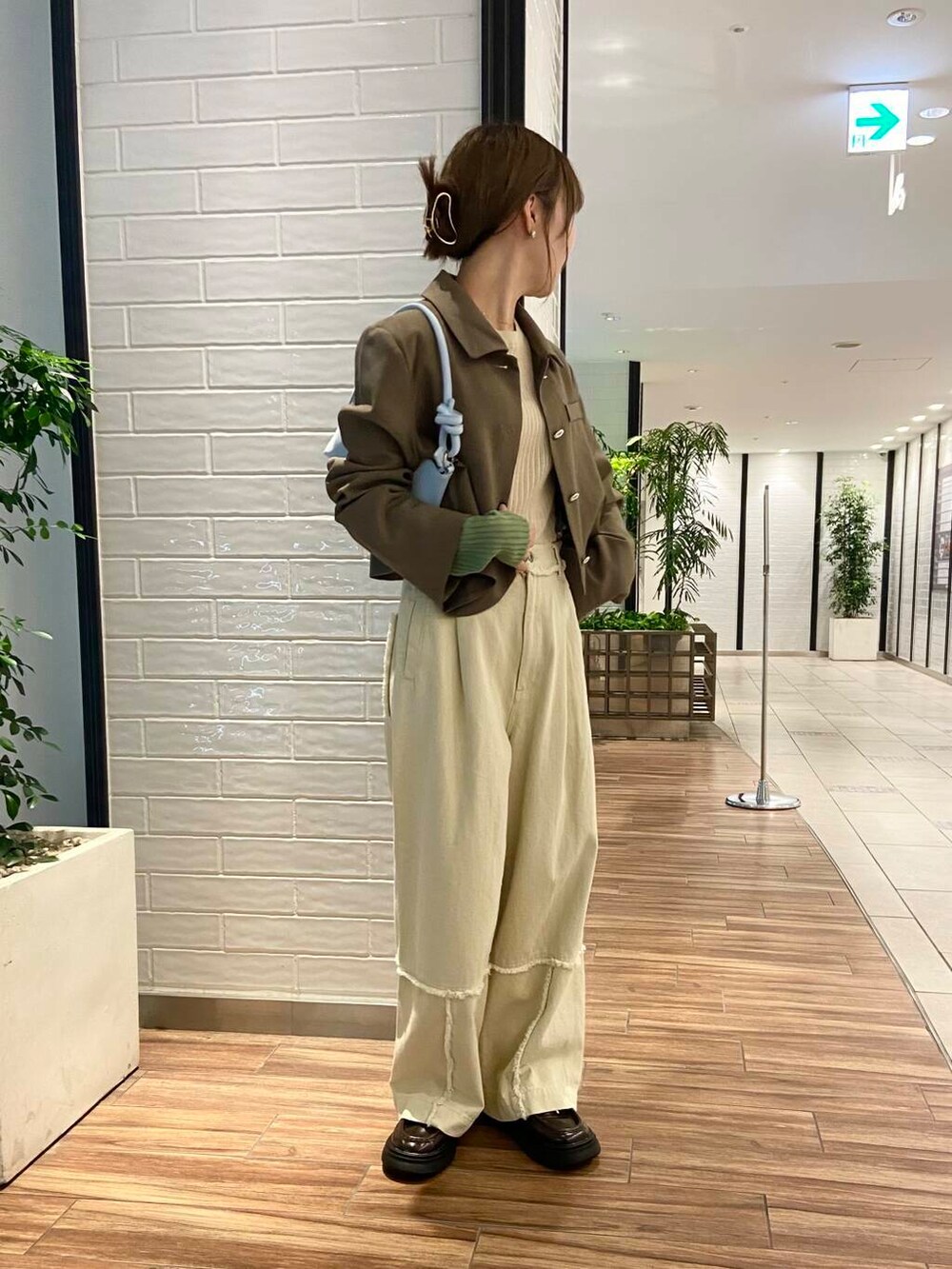 ブルー系のショルダーバッグ、ブラウン系のローファー、ホワイト系のその他パンツを着用したレディースの秋コーディネートの5枚目の写真