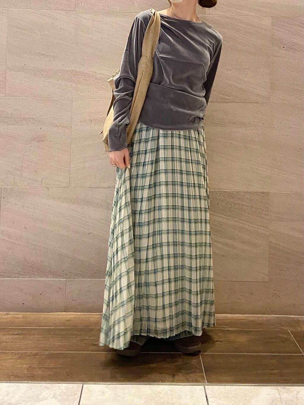 グレー系のTシャツ/カットソー、ベージュ系のショルダーバッグ、グリーン系のスカートを着用したレディースの春コーディネートの3枚目の写真