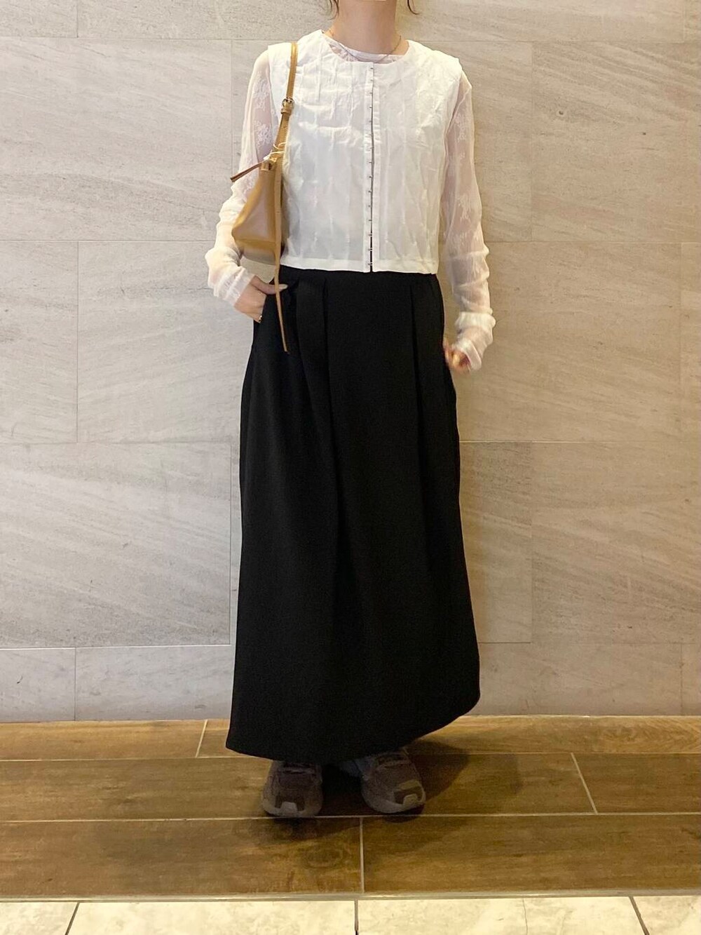 イエロー系のショルダーバッグ、ホワイト系のベスト、ホワイト系のTシャツ/カットソーを着用したレディースの春コーディネートの2枚目の写真