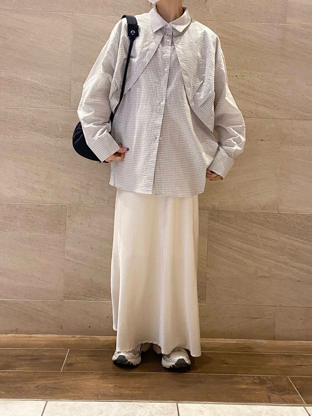 ホワイト系のスカート、ブルー系のショルダーバッグ、ホワイト系のシャツ/ブラウスを着用したレディースの冬コーディネートの2枚目の写真