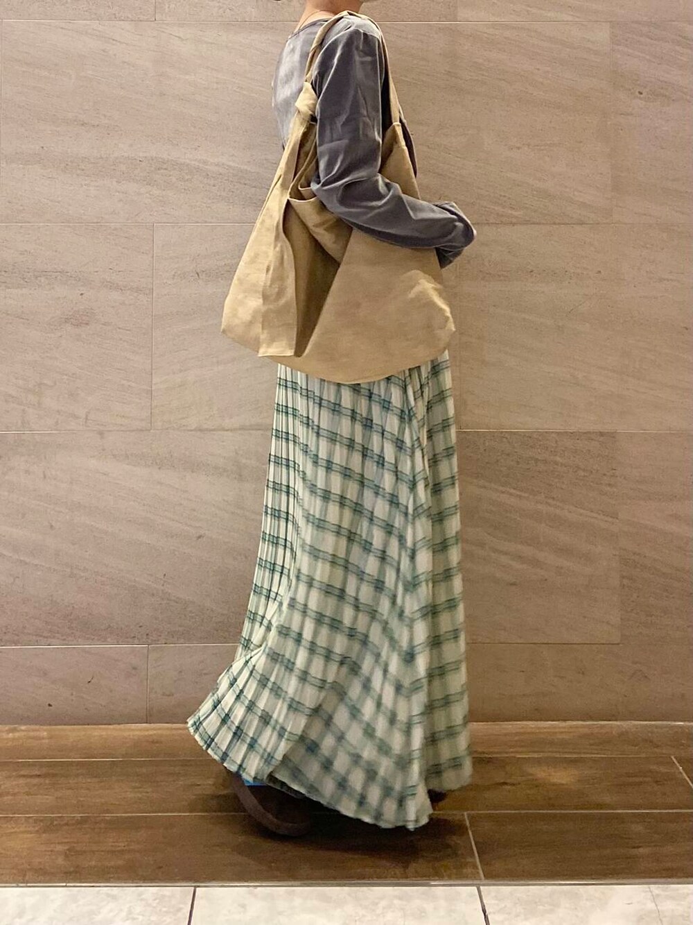 グレー系のTシャツ/カットソー、ベージュ系のショルダーバッグ、グリーン系のスカートを着用したレディースの春コーディネートの2枚目の写真