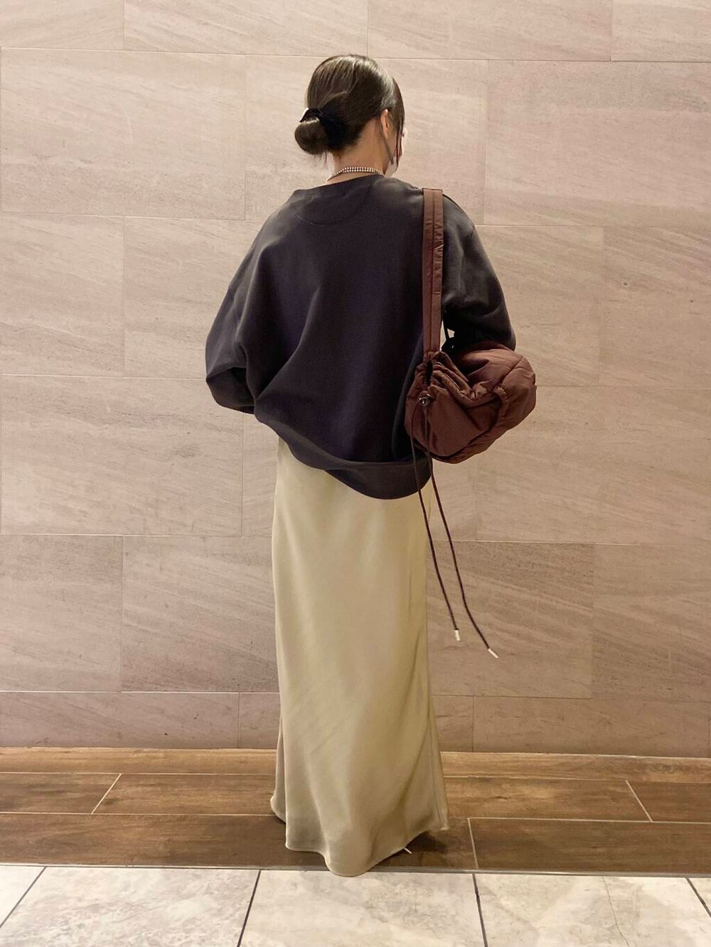 ブラウン系のショルダーバッグ、グレー系のスウェット、ベージュ系のスカートを着用したレディースの冬コーディネートの3枚目の写真