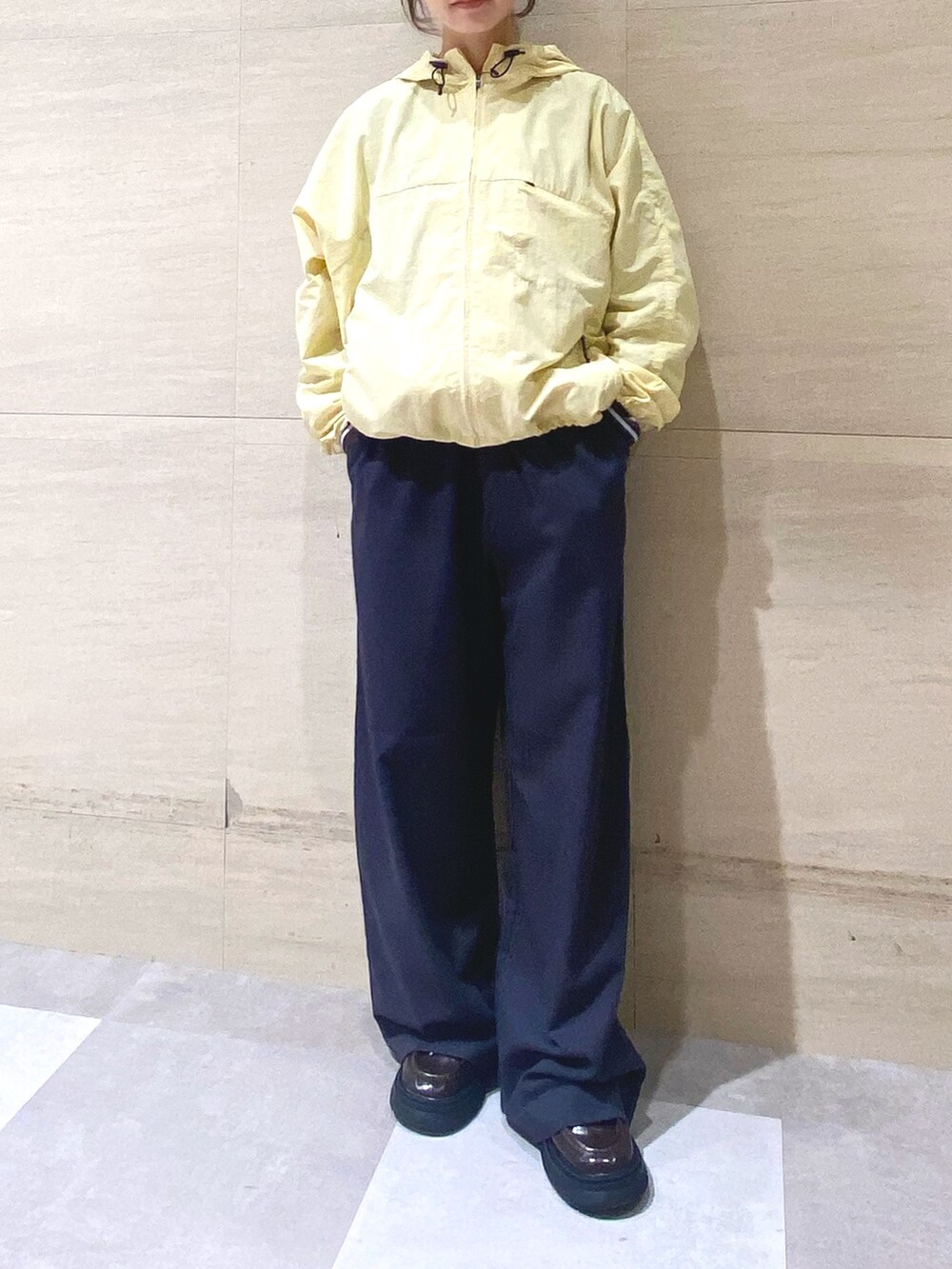 グレー系のその他パンツ、ブルー系のTシャツ/カットソー、イエロー系のナイロンジャケットを着用したレディースの冬コーディネートの4枚目の写真