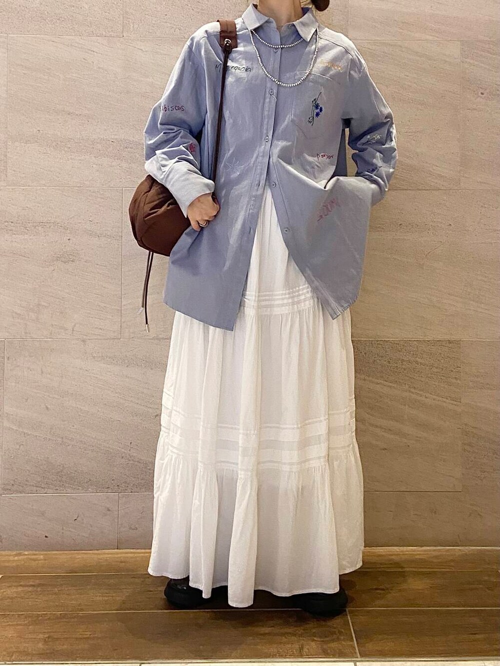 ブラウン系のローファー、ブラウン系のショルダーバッグ、ブルー系のシャツ/ブラウスを着用したレディースの冬コーディネートの5枚目の写真