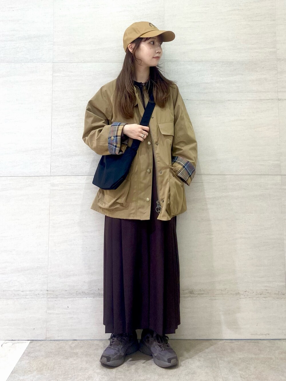 ブラック系のショルダーバッグ、ブラウン系のワンピース、ベージュ系のその他アウターを着用したレディースの秋コーディネートの6枚目の写真