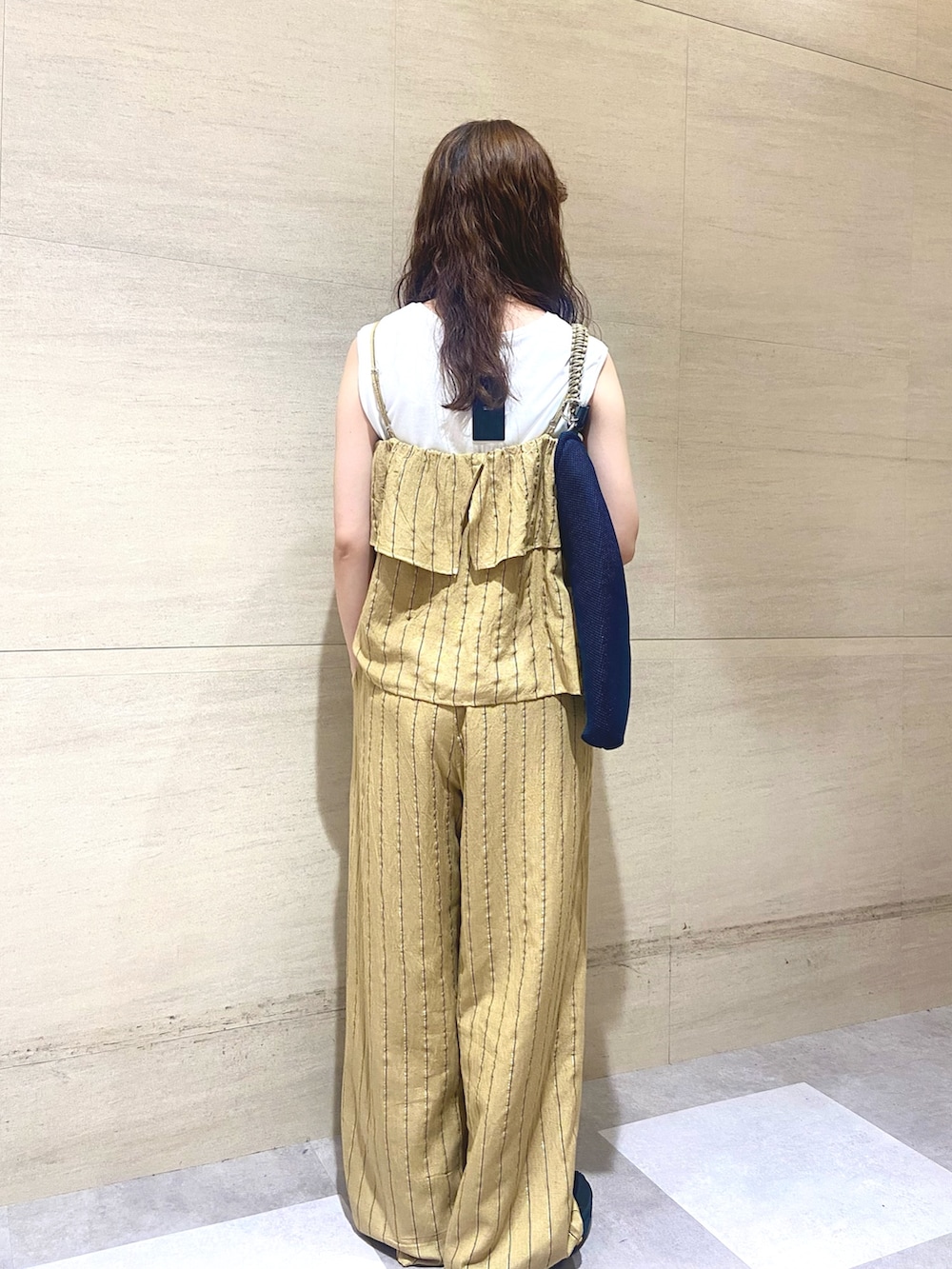 イエロー系のワンピース、ホワイト系のタンクトップ、ブルー系のトートバッグを着用したレディースの夏コーディネートの2枚目の写真