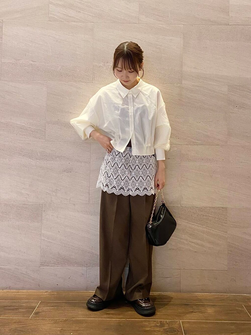 ブラウン系のローファー、ブラック系のショルダーバッグ、ホワイト系のシャツ/ブラウスを着用したレディースの冬コーディネートの2枚目の写真