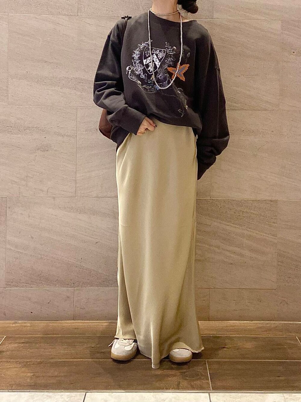 ブラウン系のショルダーバッグ、グレー系のスウェット、ベージュ系のスカートを着用したレディースの冬コーディネートの4枚目の写真