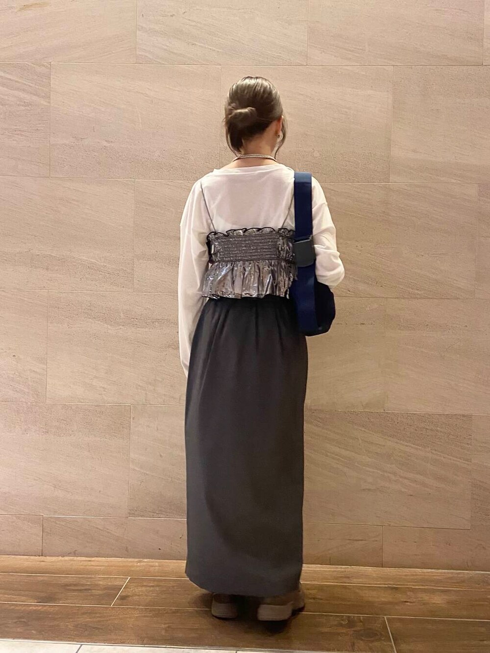 ブルー系のショルダーバッグ、グレー系のスカート、シルバー系のベストを着用したレディースの秋コーディネートの4枚目の写真