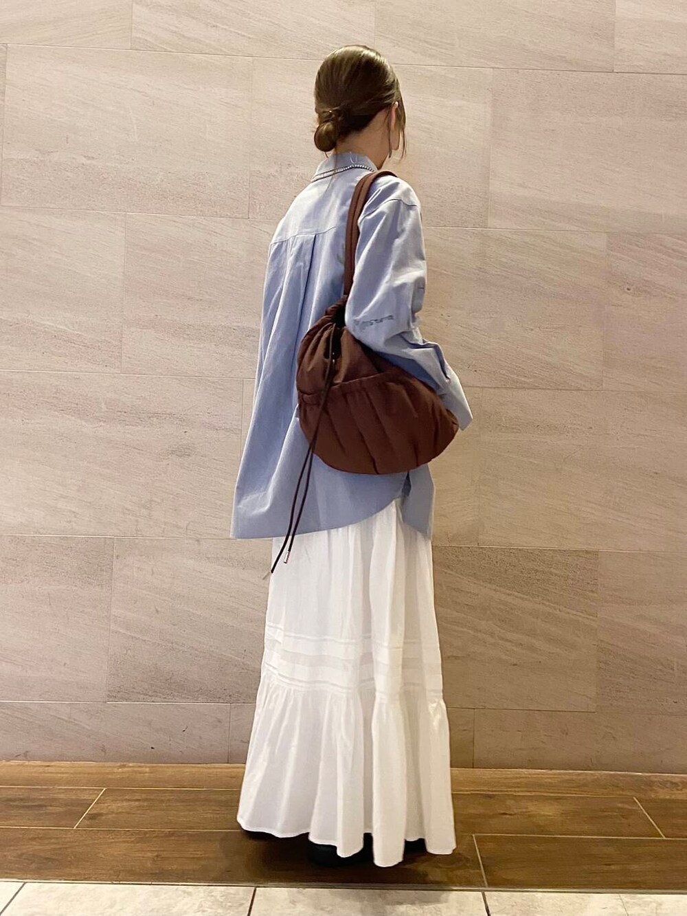 ブラウン系のローファー、ブラウン系のショルダーバッグ、ブルー系のシャツ/ブラウスを着用したレディースの冬コーディネートの3枚目の写真