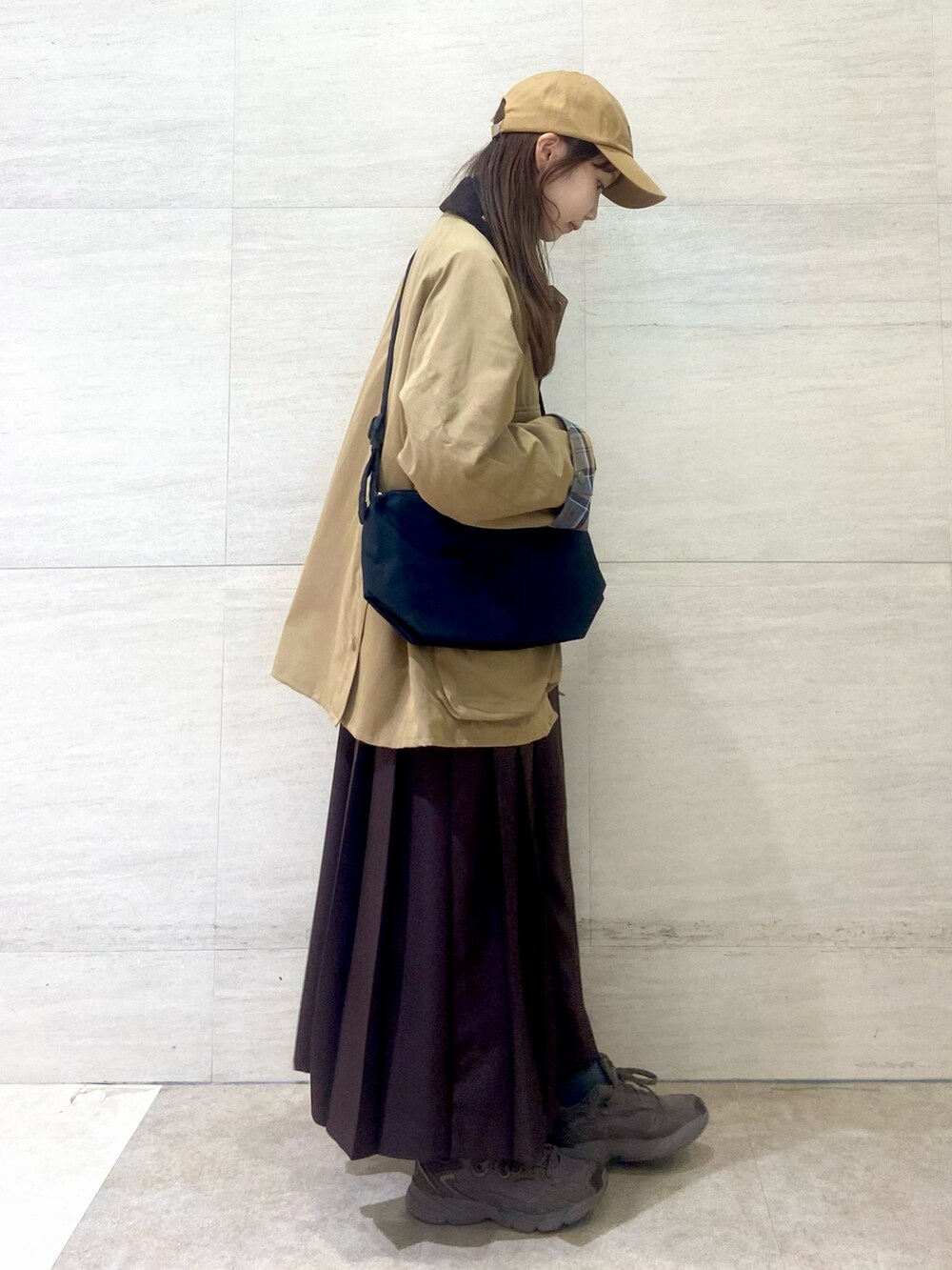 ブラック系のショルダーバッグ、ブラウン系のワンピース、ベージュ系のその他アウターを着用したレディースの秋コーディネートの4枚目の写真