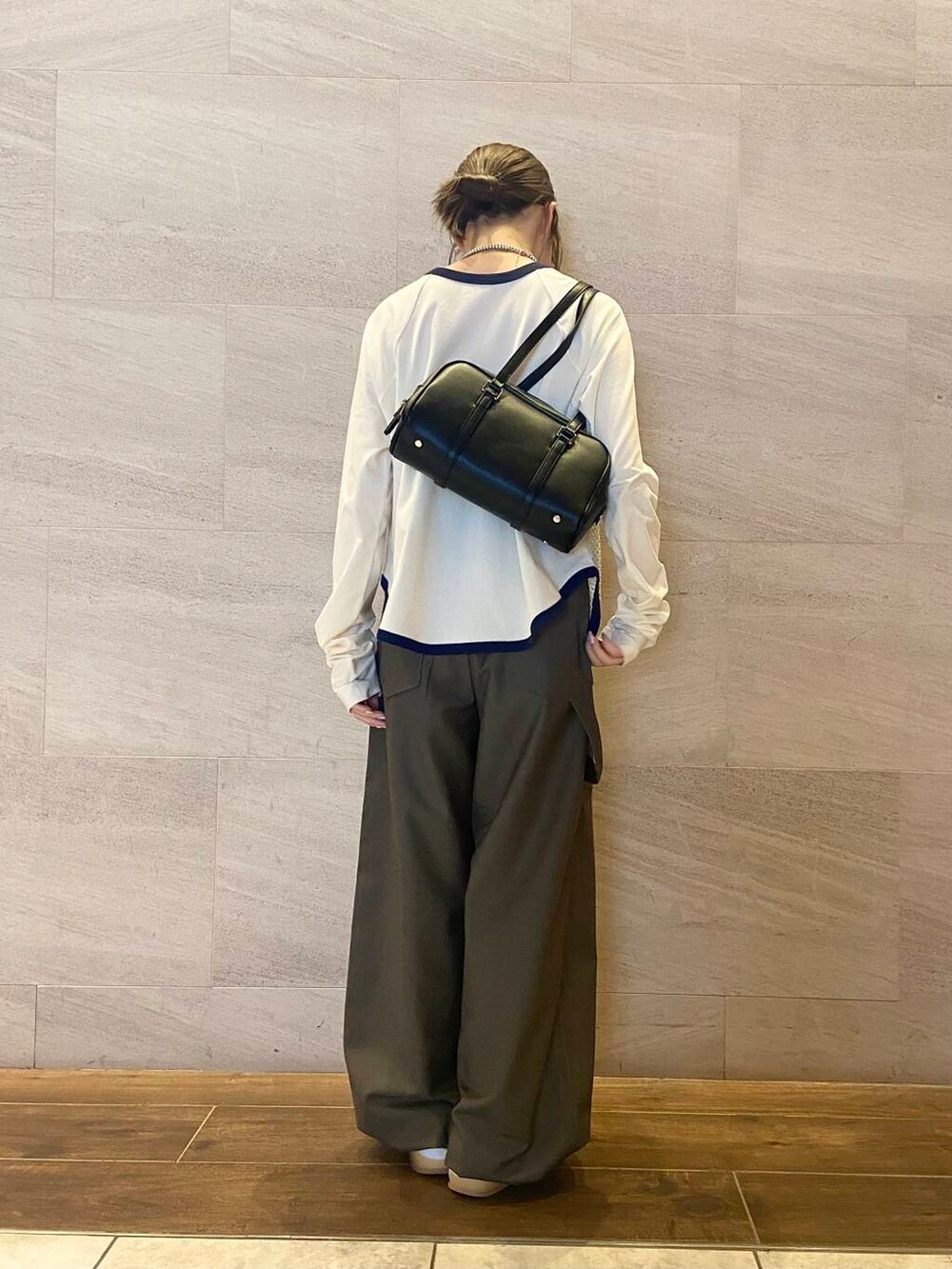 ブラック系のボストンバッグ、グリーン系のスラックス、ホワイト系のTシャツ/カットソーを着用したレディースの秋コーディネートの4枚目の写真