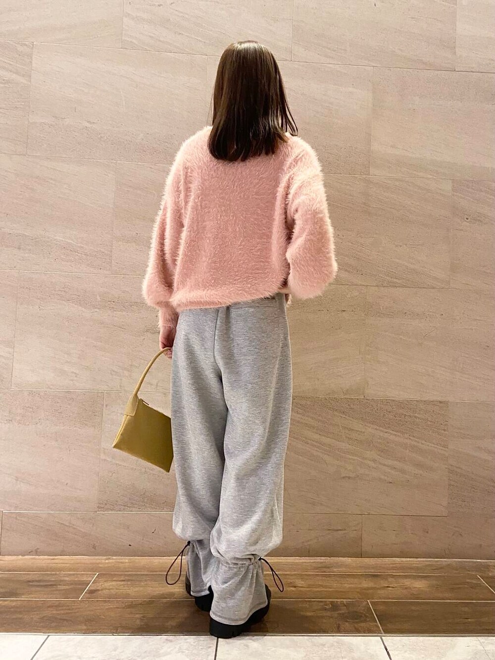 ブラック系のブーツ、ベージュ系のショルダーバッグ、グレー系のその他パンツを着用したレディースの冬コーディネートの3枚目の写真