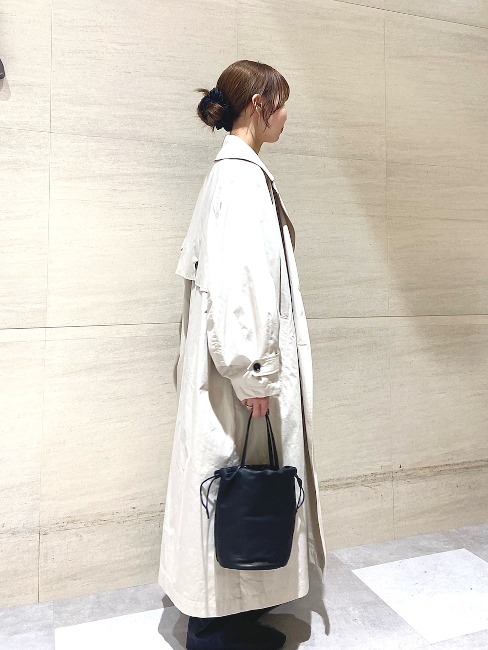 ベージュ系のトレンチコート、ピンク系のニット/セーター、ブラック系のショルダーバッグを着用したレディースの春コーディネートの3枚目の写真