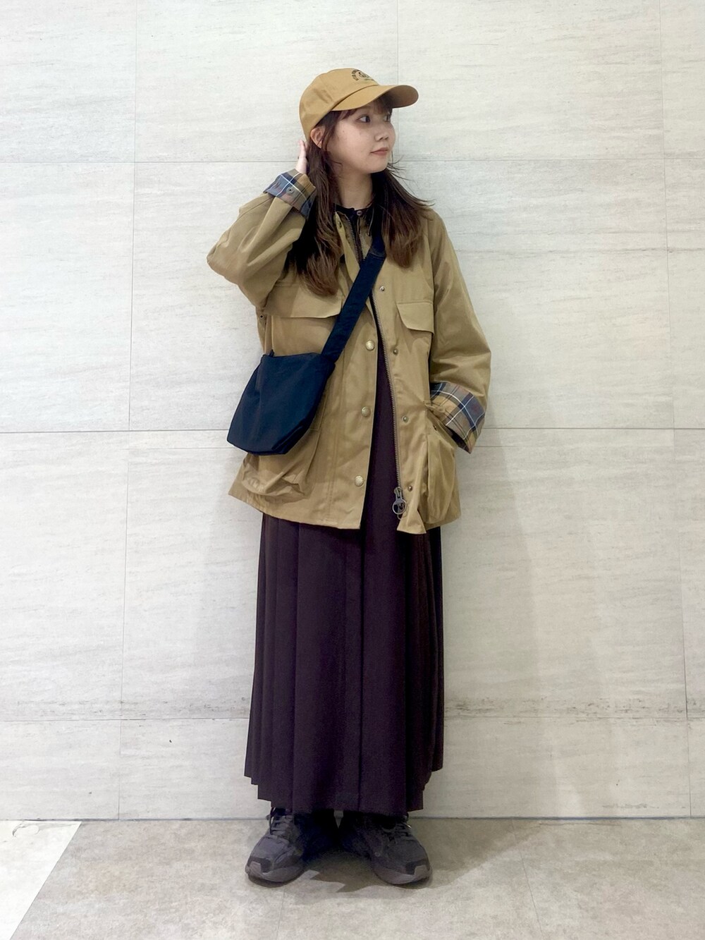 ブラック系のショルダーバッグ、ブラウン系のワンピース、ベージュ系のその他アウターを着用したレディースの秋コーディネートの3枚目の写真