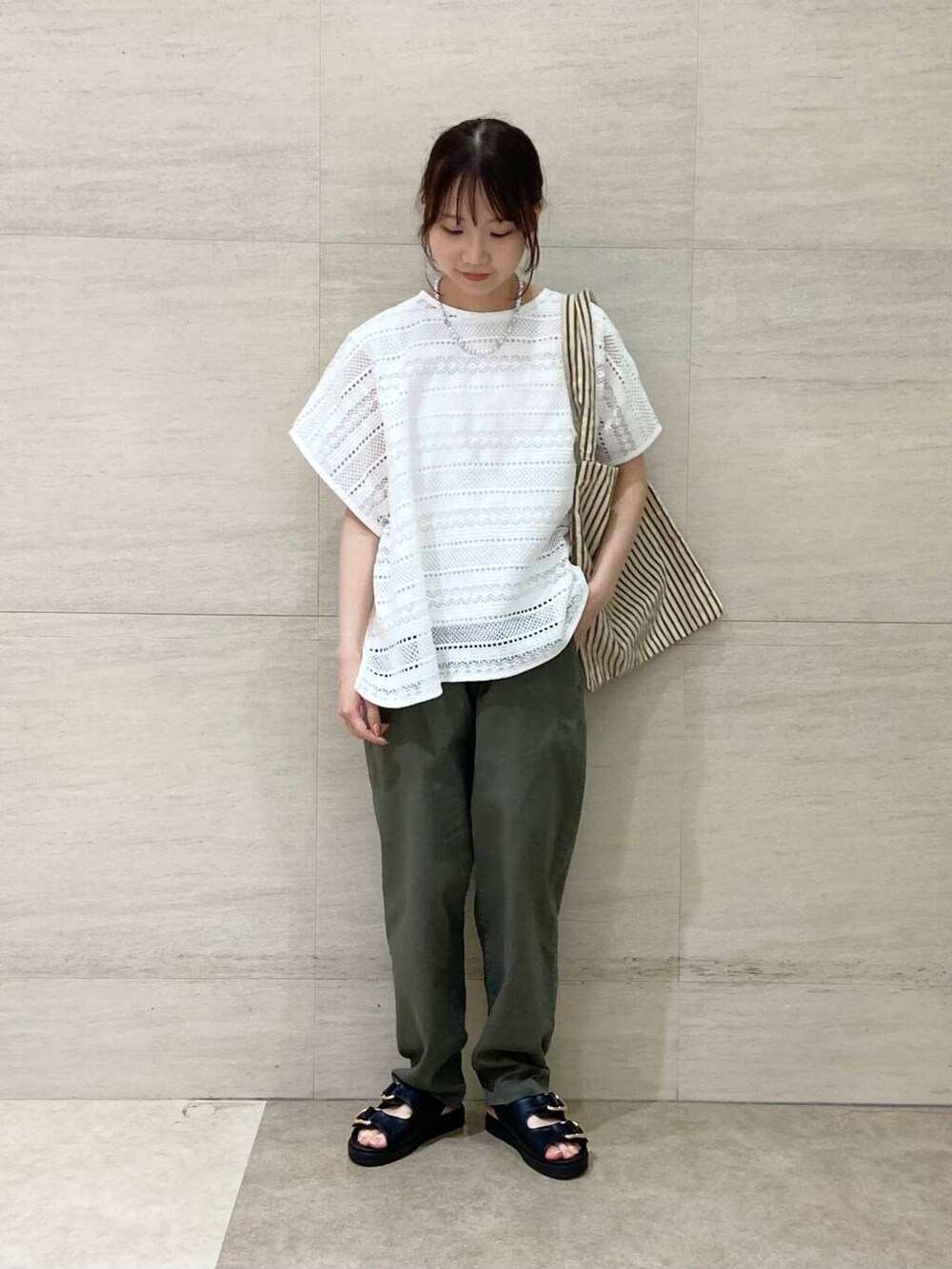 ブラウン系のエコバッグ/サブバッグ、グリーン系のその他パンツ、ブラック系のサンダルを着用したレディースの夏コーディネートの2枚目の写真