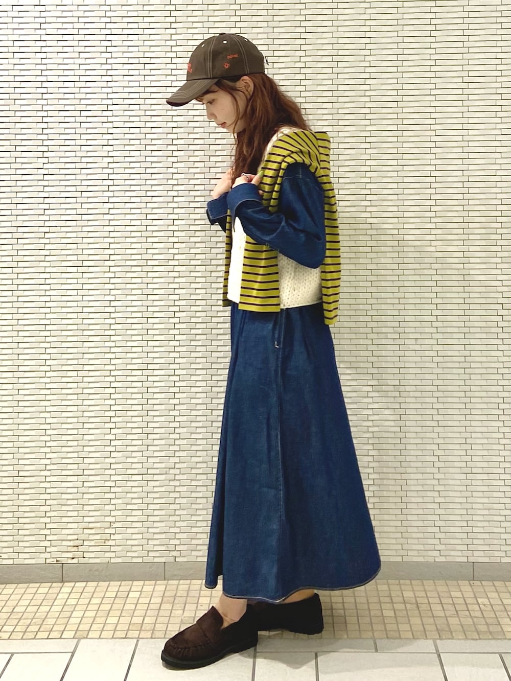ホワイト系のベスト、イエロー系のTシャツ/カットソー、ブラウン系のローファーを着用したレディースの秋コーディネートの3枚目の写真