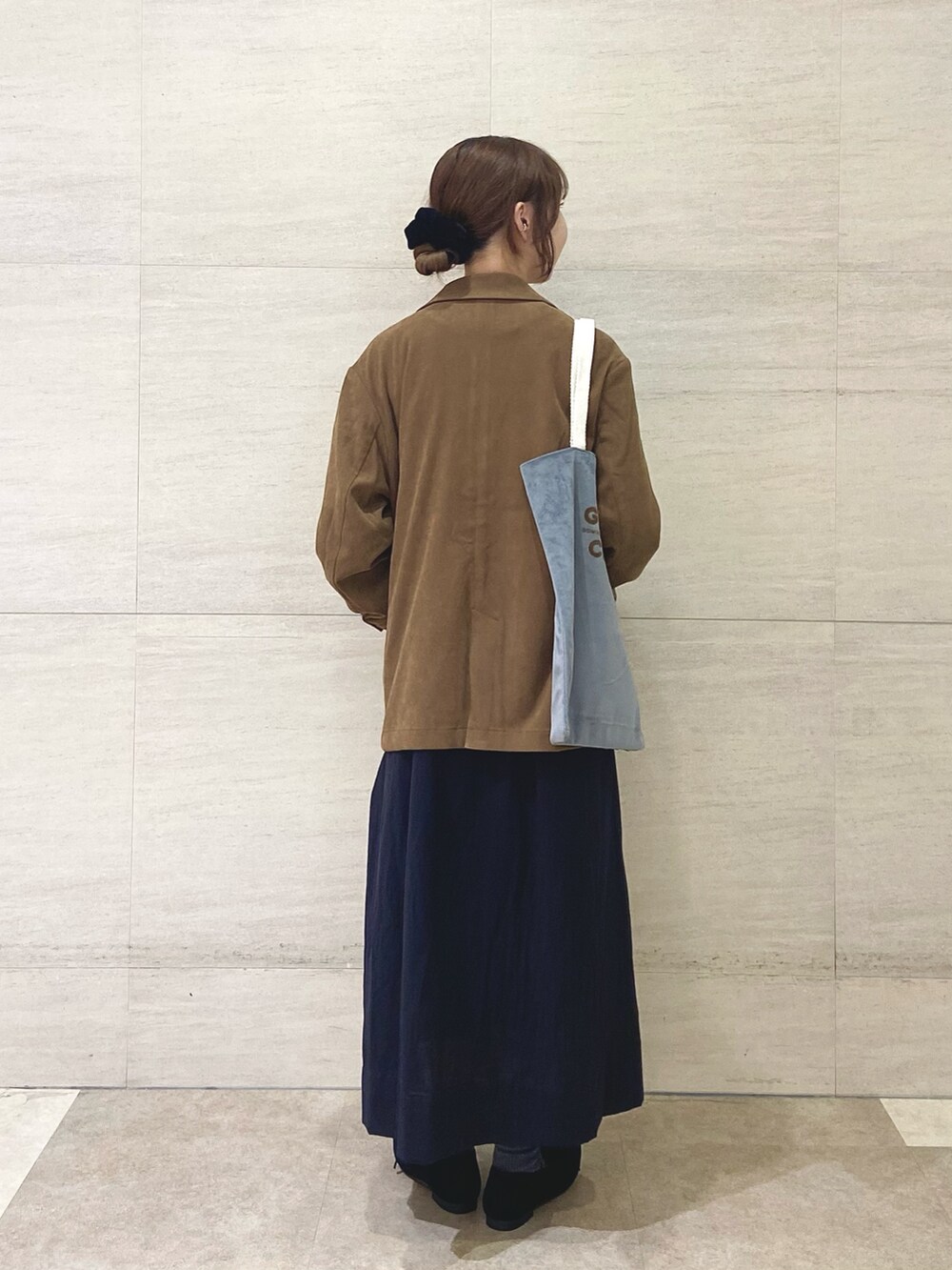 ブラック系のワンピース、ベージュ系のその他アウター、グレー系のトートバッグを着用したレディースの秋コーディネートの5枚目の写真