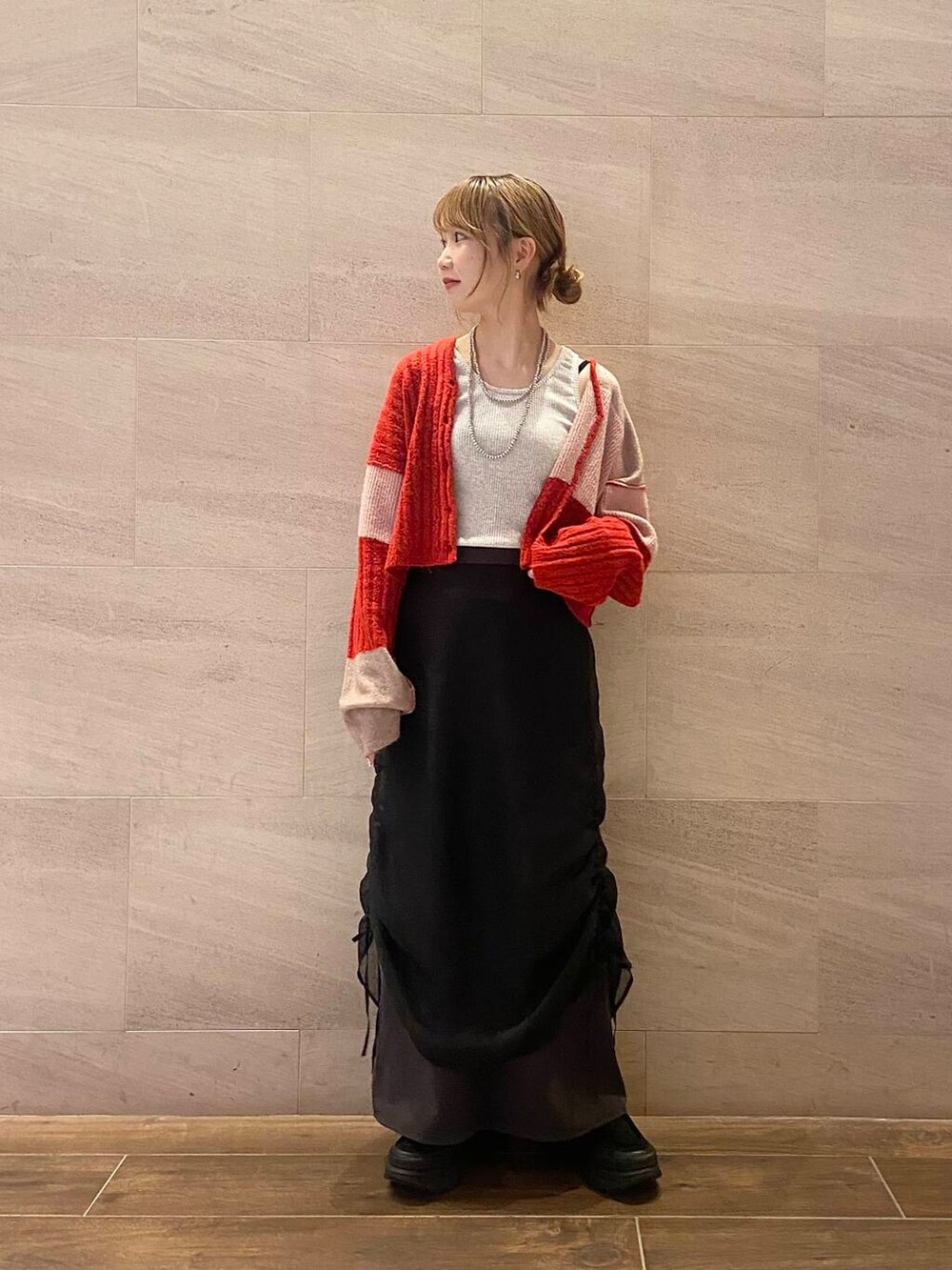 ブラック系のスカート、ブラック系のスニーカー、ベージュ系のタンクトップを着用したレディースの夏コーディネートの6枚目の写真