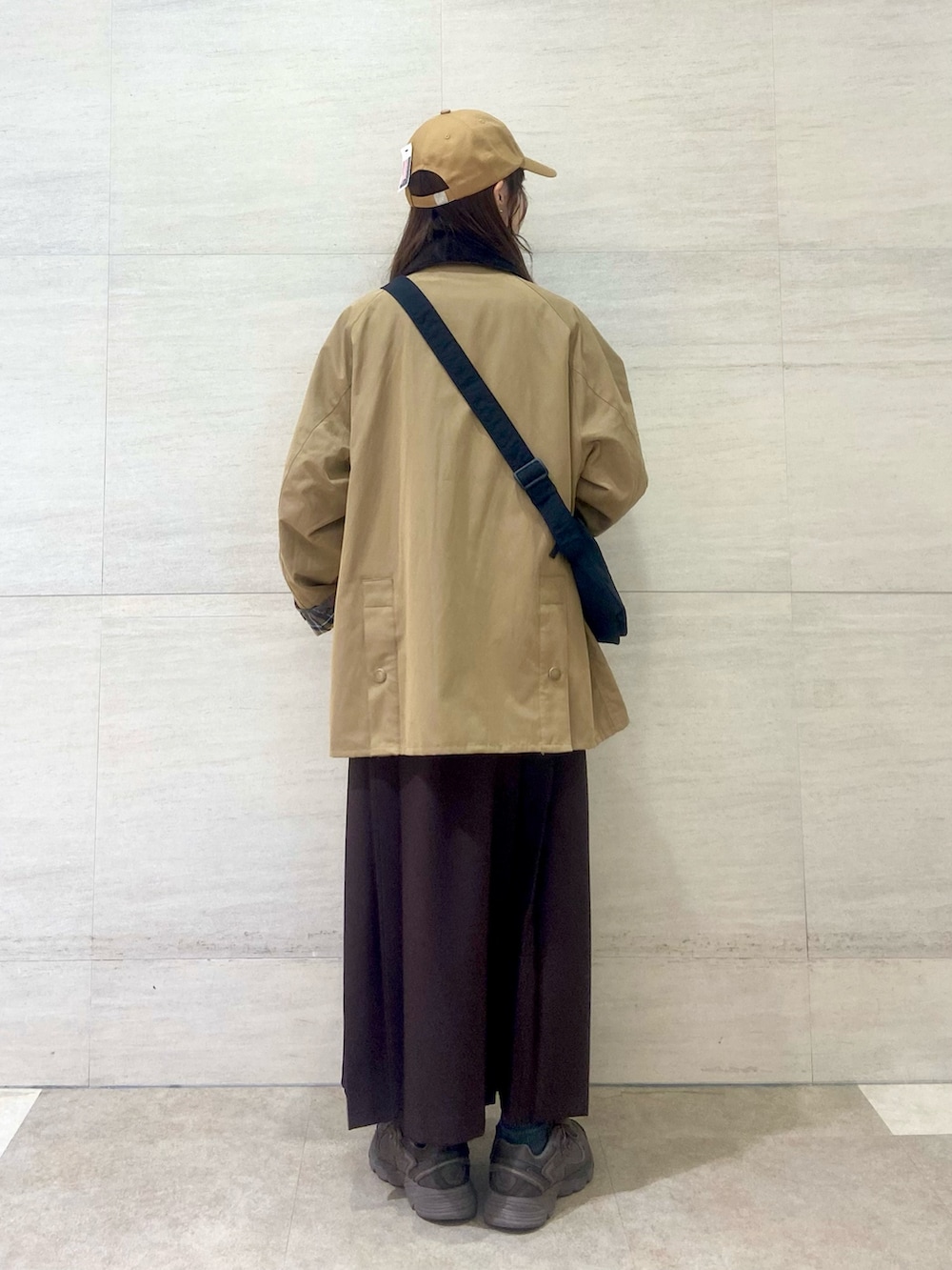 ブラック系のショルダーバッグ、ブラウン系のワンピース、ベージュ系のその他アウターを着用したレディースの秋コーディネートの5枚目の写真