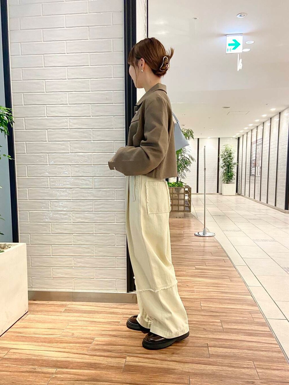 ブルー系のショルダーバッグ、ブラウン系のローファー、ホワイト系のその他パンツを着用したレディースの秋コーディネートの3枚目の写真