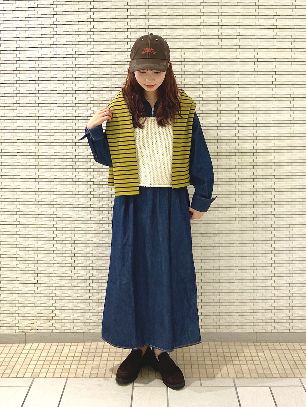 ホワイト系のベスト、イエロー系のTシャツ/カットソー、ブラウン系のローファーを着用したレディースの秋コーディネートの2枚目の写真