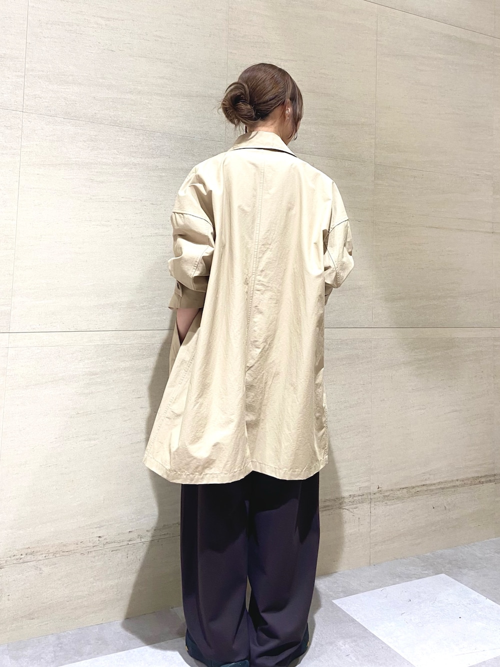 ベージュ系のステンカラーコート、ブラウン系のその他パンツ、ベージュ系のその他トップスを着用したレディースの春コーディネートの5枚目の写真