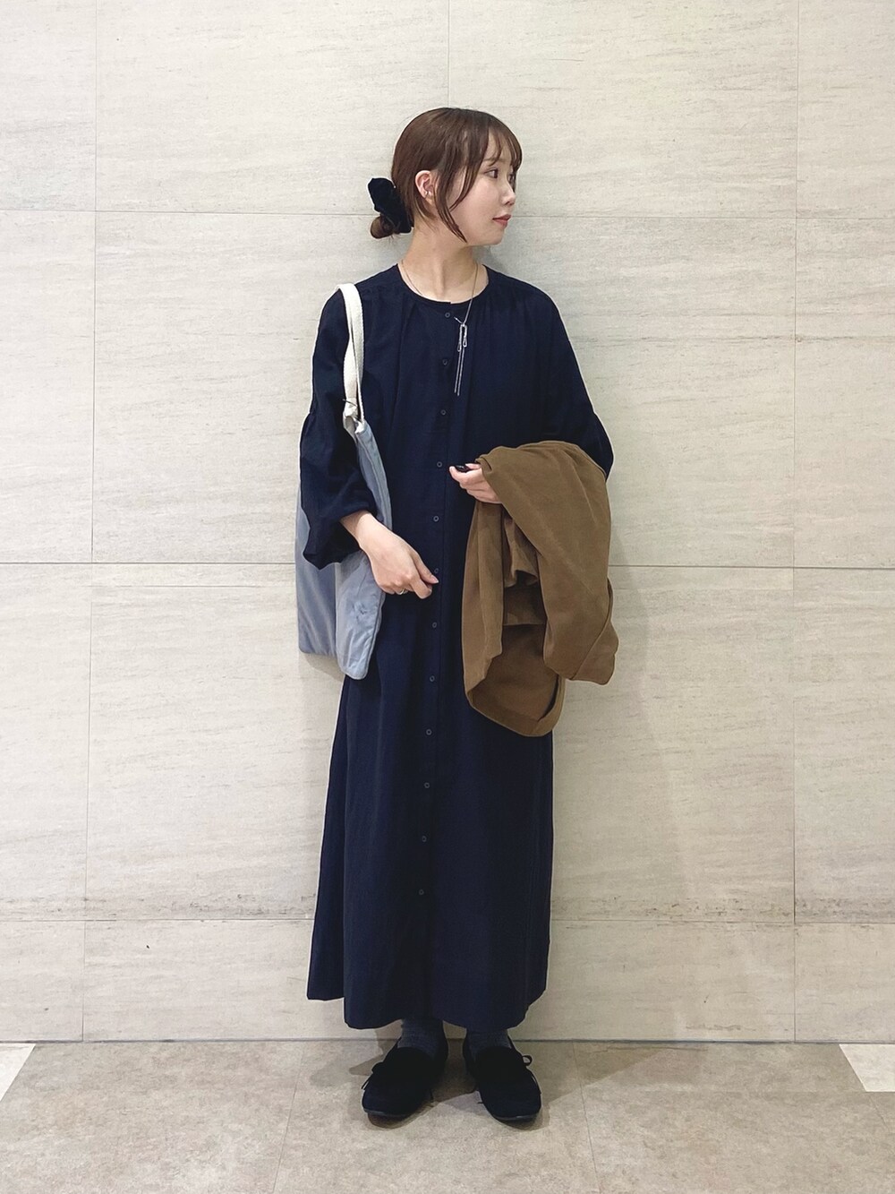 ブラック系のワンピース、ベージュ系のその他アウター、グレー系のトートバッグを着用したレディースの秋コーディネートの3枚目の写真