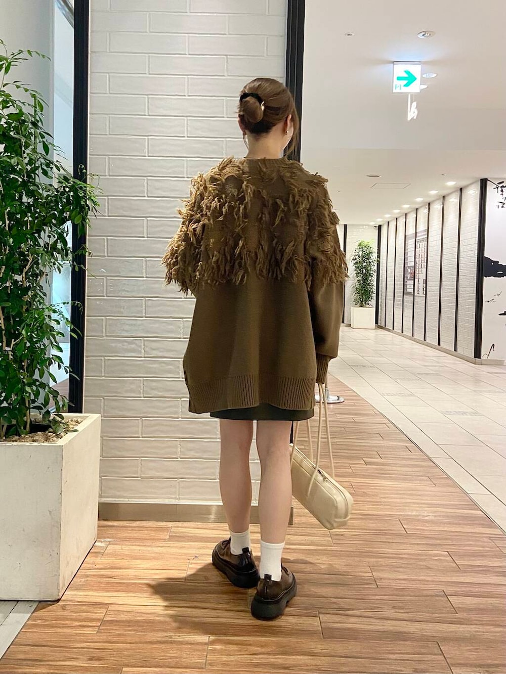 ブラウン系のローファー、グリーン系のカーディガン/ボレロ、ブラウン系のTシャツ/カットソーを着用したレディースの秋コーディネートの4枚目の写真