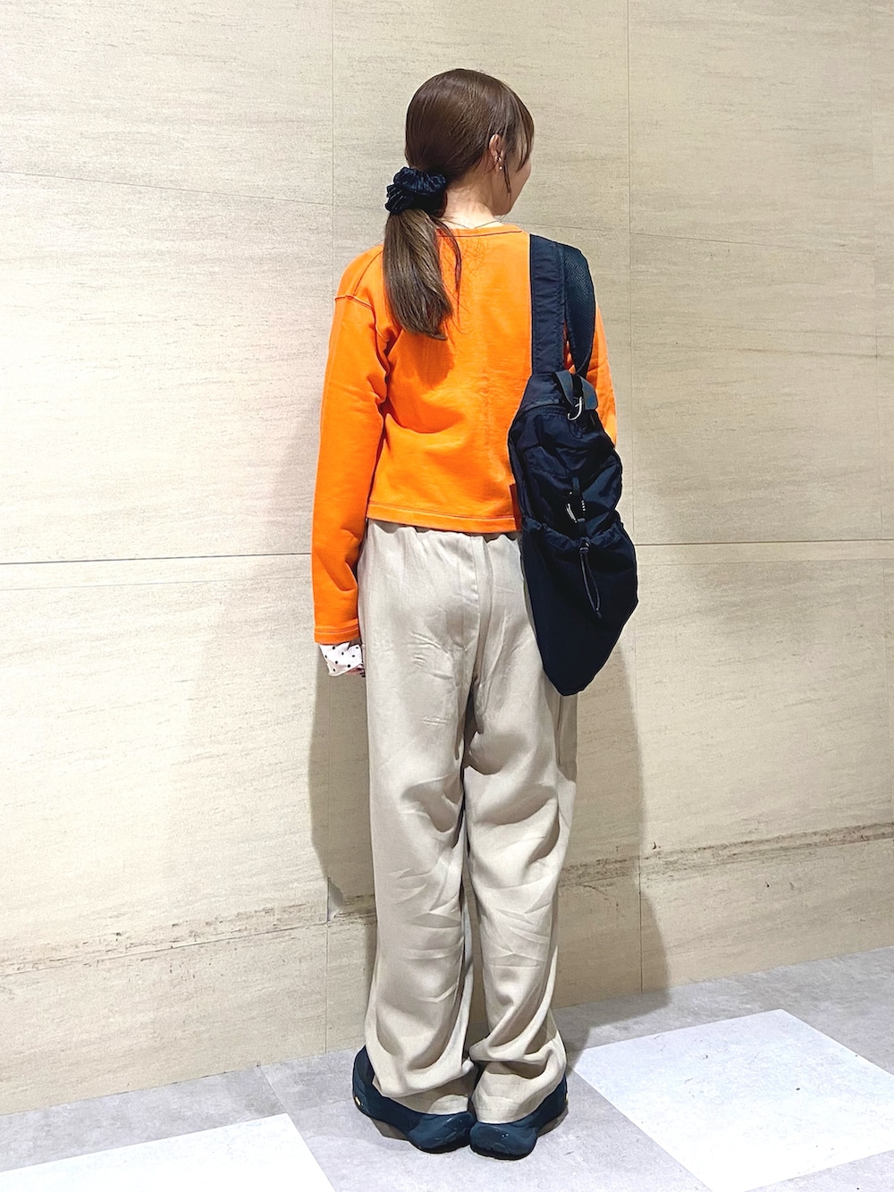 オレンジ系のカーディガン/ボレロ、ブラック系のバックパック/リュック、ベージュ系のその他パンツを着用したレディースの春コーディネートの2枚目の写真