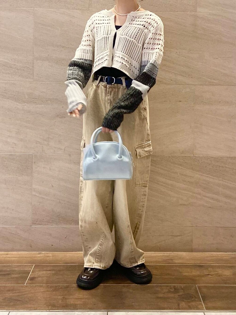 ブルー系のボストンバッグ、ホワイト系のカーディガン/ボレロ、ベージュ系のデニムパンツを着用したレディースの春コーディネートの5枚目の写真