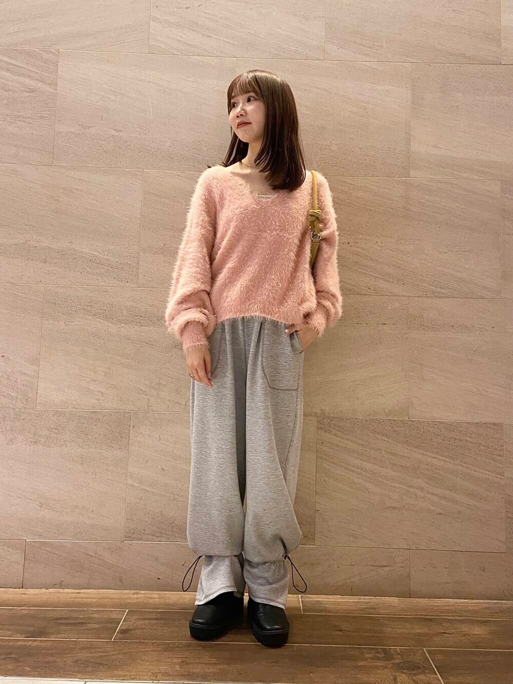 ブラック系のブーツ、ベージュ系のショルダーバッグ、グレー系のその他パンツを着用したレディースの冬コーディネートの4枚目の写真