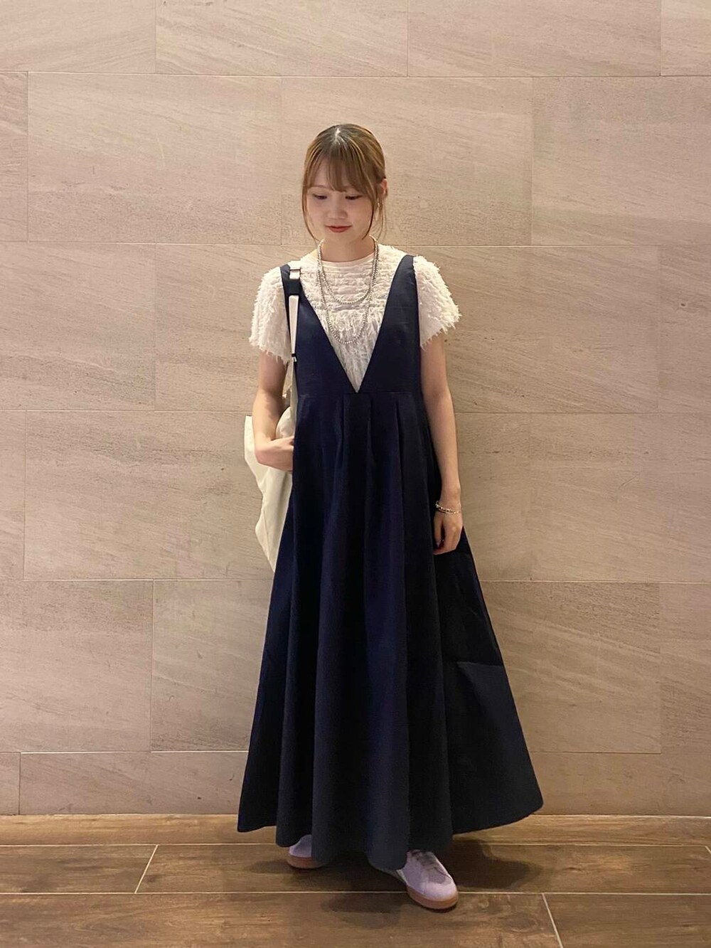 ホワイト系のショルダーバッグ、ブルー系のワンピース、パープル系のスニーカーを着用したレディースの夏コーディネートの5枚目の写真