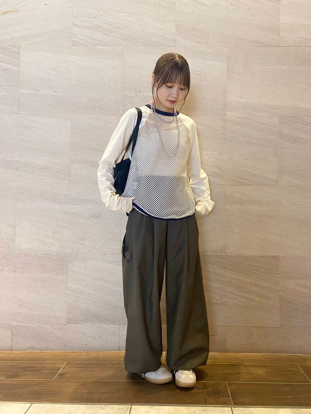 ブラック系のボストンバッグ、グリーン系のスラックス、ホワイト系のTシャツ/カットソーを着用したレディースの秋コーディネートの2枚目の写真