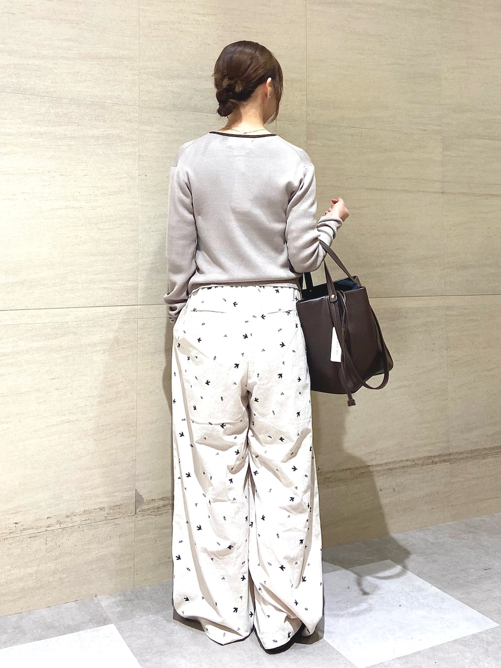 グレー系のカーディガン/ボレロ、ホワイト系のその他パンツ、ブラウン系のトートバッグを着用したレディースの冬コーディネートの3枚目の写真