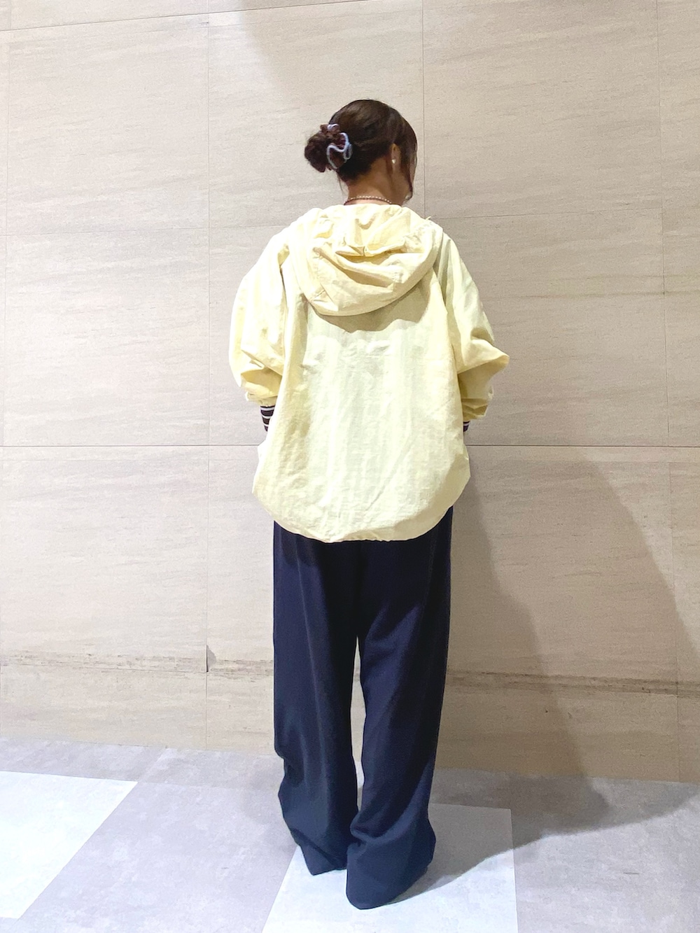 グレー系のその他パンツ、ブルー系のTシャツ/カットソー、イエロー系のナイロンジャケットを着用したレディースの冬コーディネートの3枚目の写真