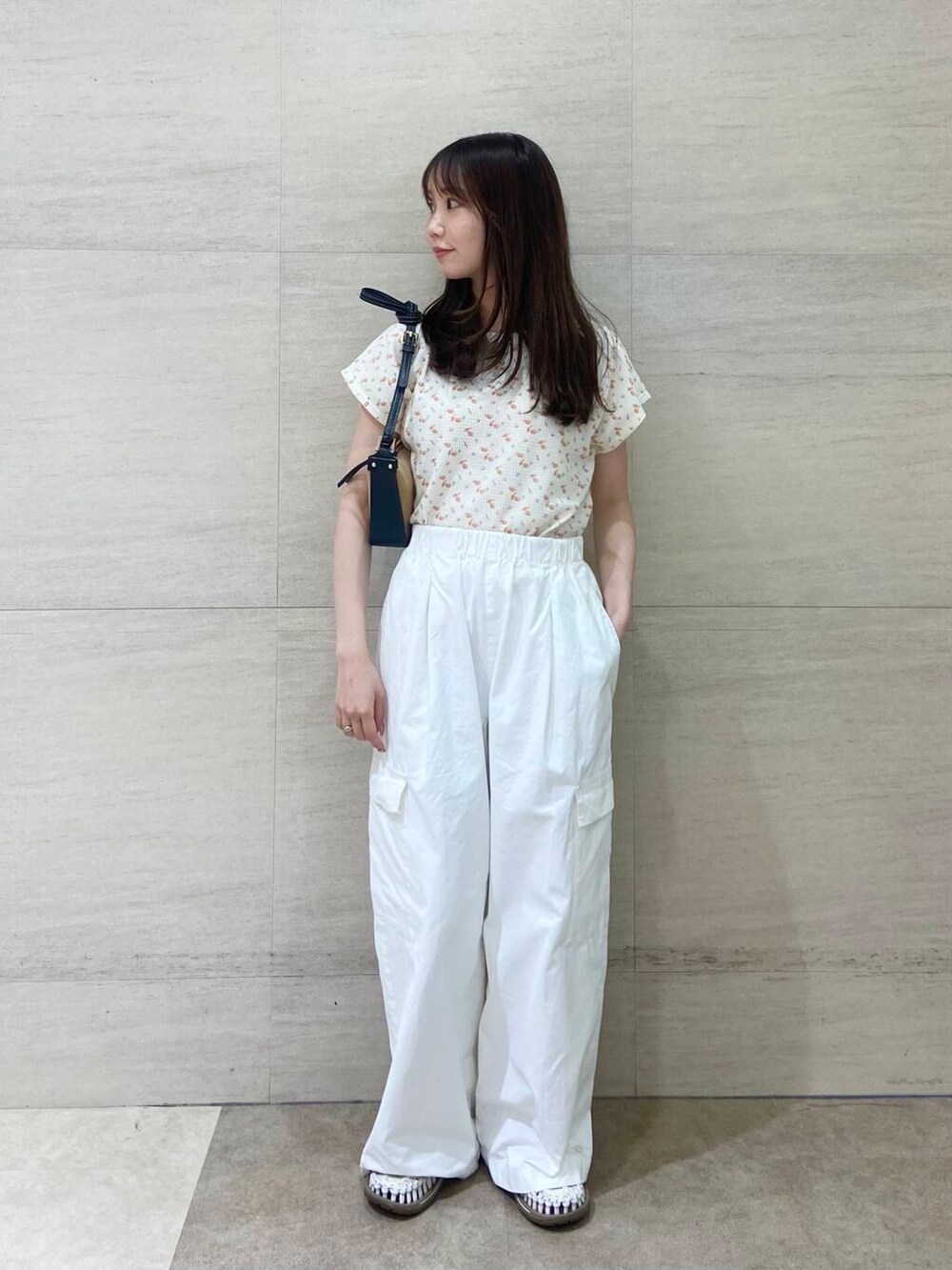 ブラック系のショルダーバッグ、ホワイト系のTシャツ/カットソー、ホワイト系のその他パンツを着用したレディースの春コーディネートの2枚目の写真