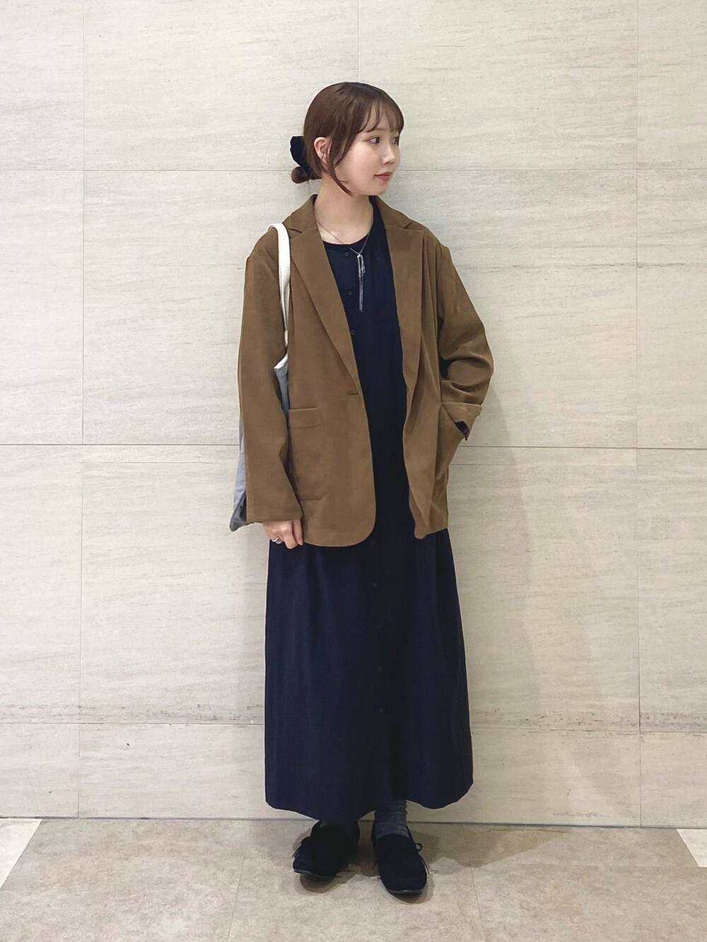 ブラック系のワンピース、ベージュ系のその他アウター、グレー系のトートバッグを着用したレディースの秋コーディネートの2枚目の写真