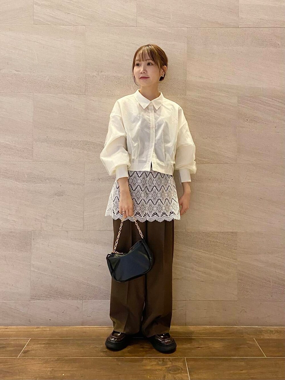 ブラウン系のローファー、ブラック系のショルダーバッグ、ホワイト系のシャツ/ブラウスを着用したレディースの冬コーディネートの5枚目の写真