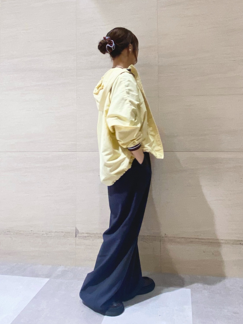 グレー系のその他パンツ、ブルー系のTシャツ/カットソー、イエロー系のナイロンジャケットを着用したレディースの冬コーディネートの2枚目の写真