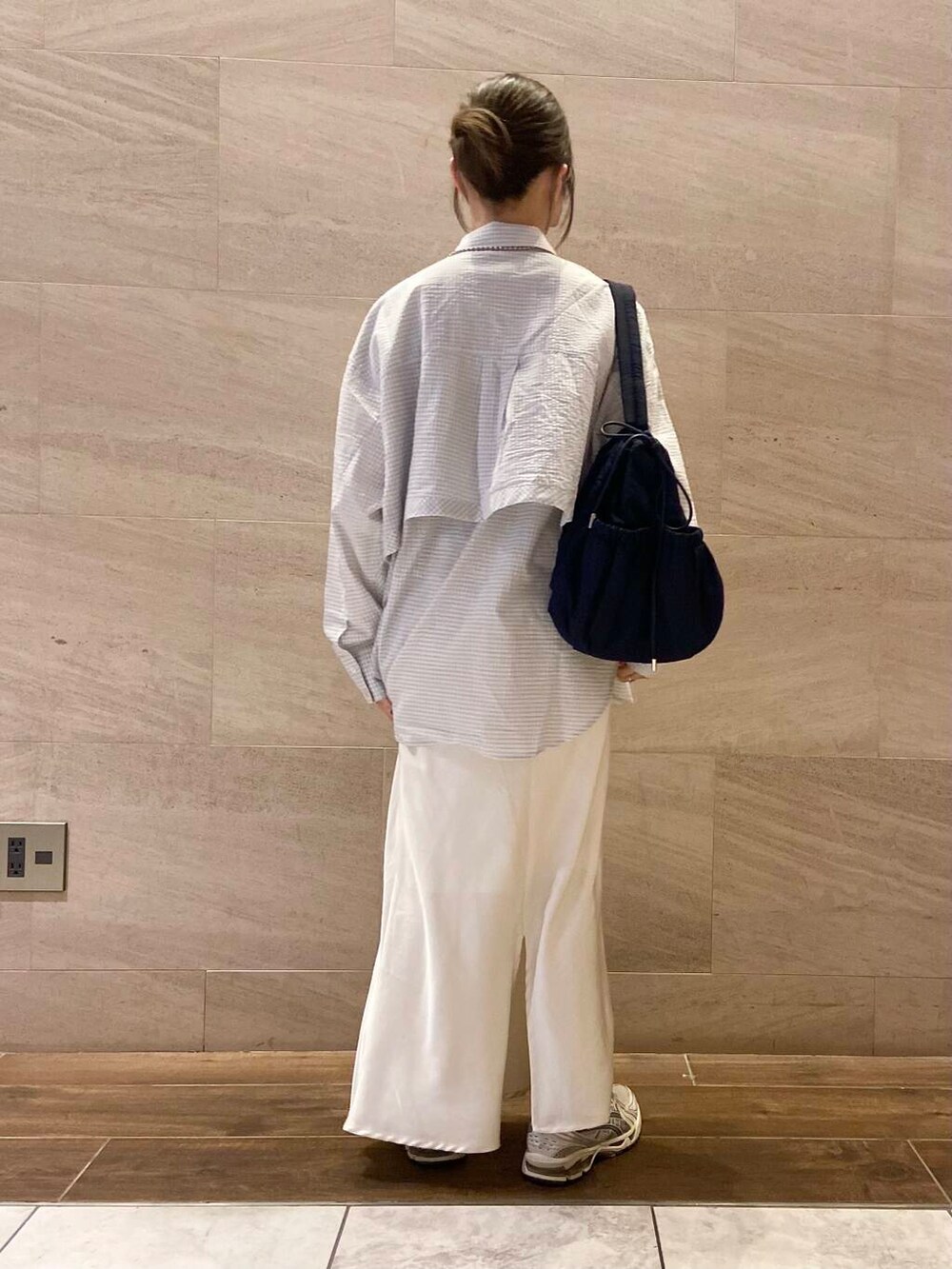 ホワイト系のスカート、ブルー系のショルダーバッグ、ホワイト系のシャツ/ブラウスを着用したレディースの冬コーディネートの4枚目の写真