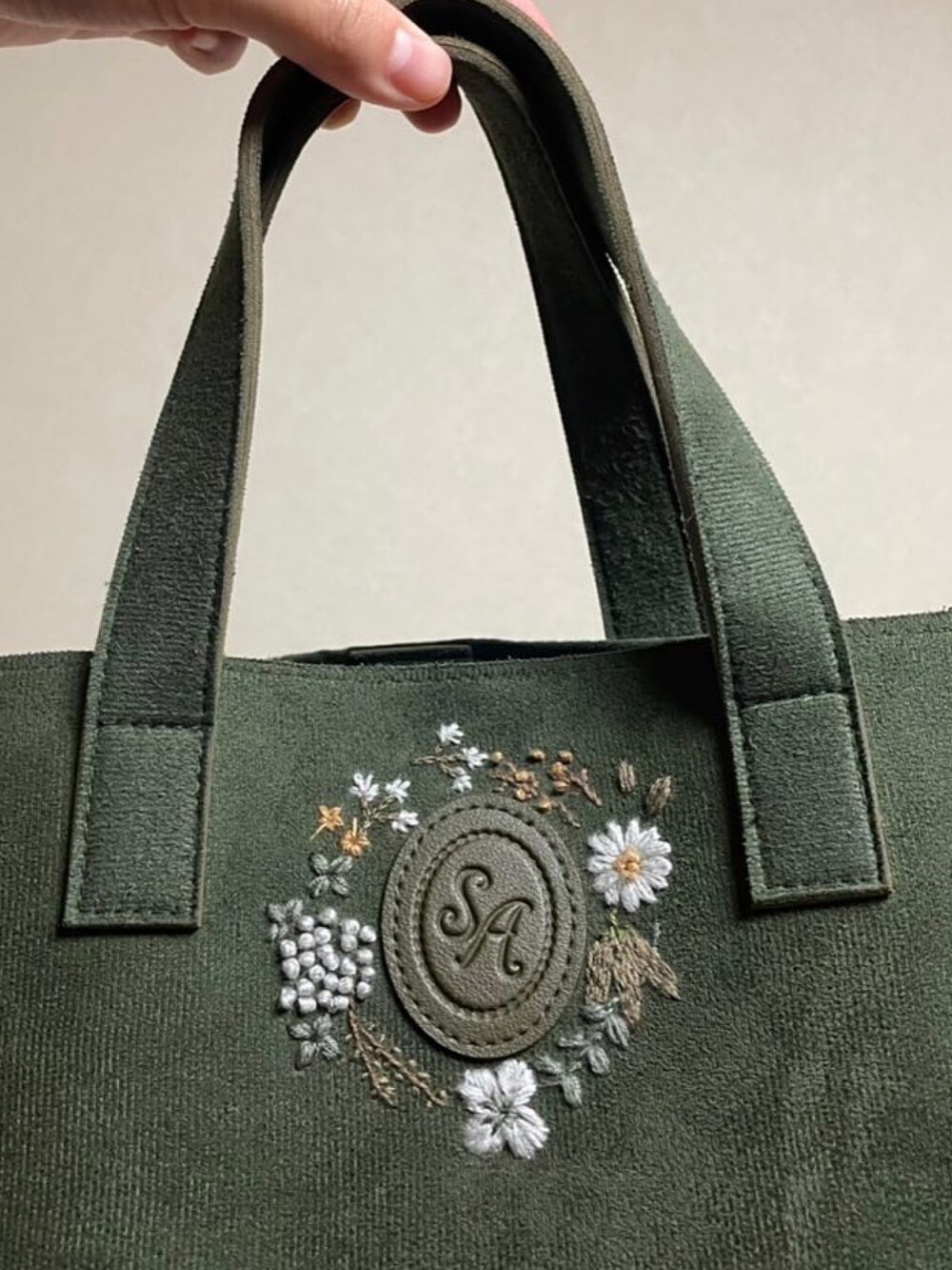 グリーン系のショルダーバッグを着用したレディースの秋コーディネートの2枚目の写真