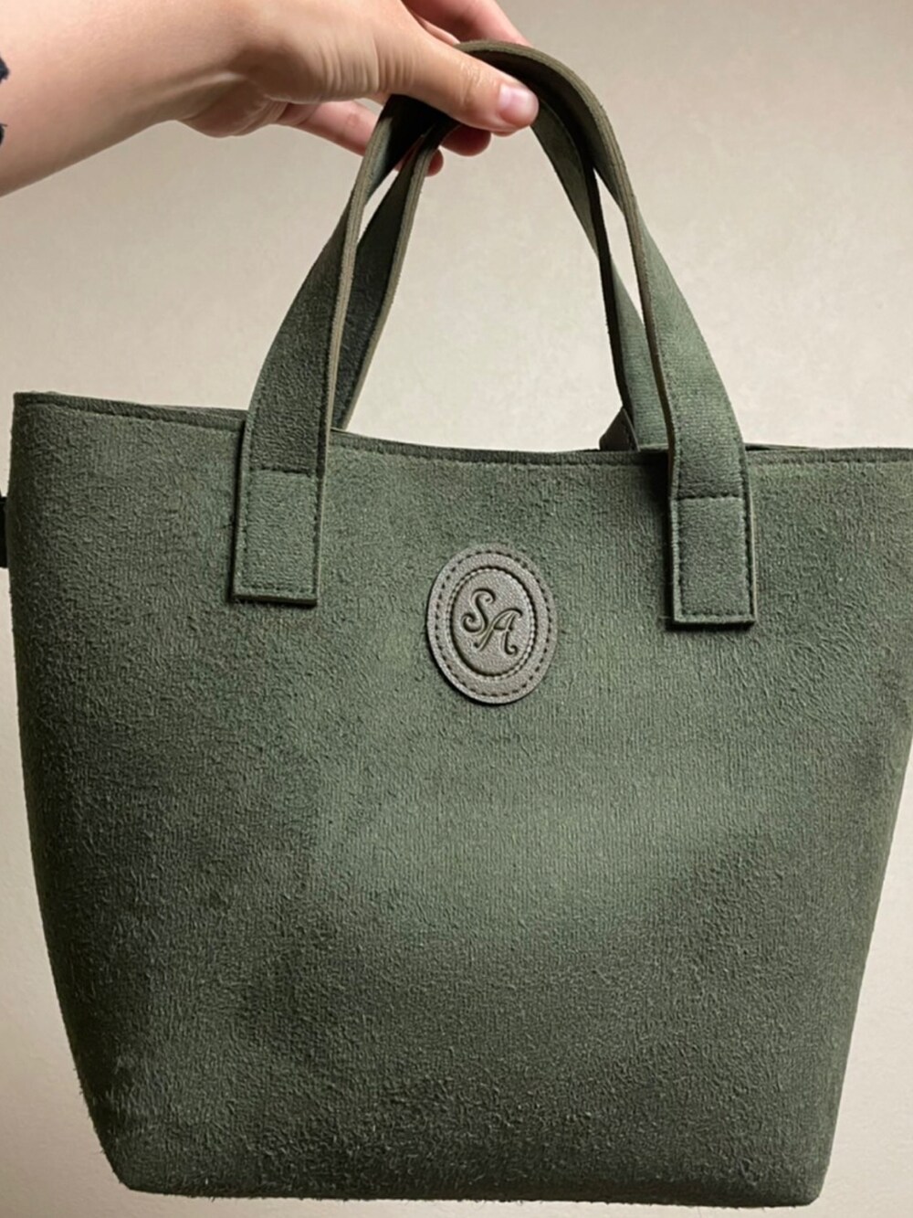 グリーン系のショルダーバッグを着用したレディースの秋コーディネートの3枚目の写真