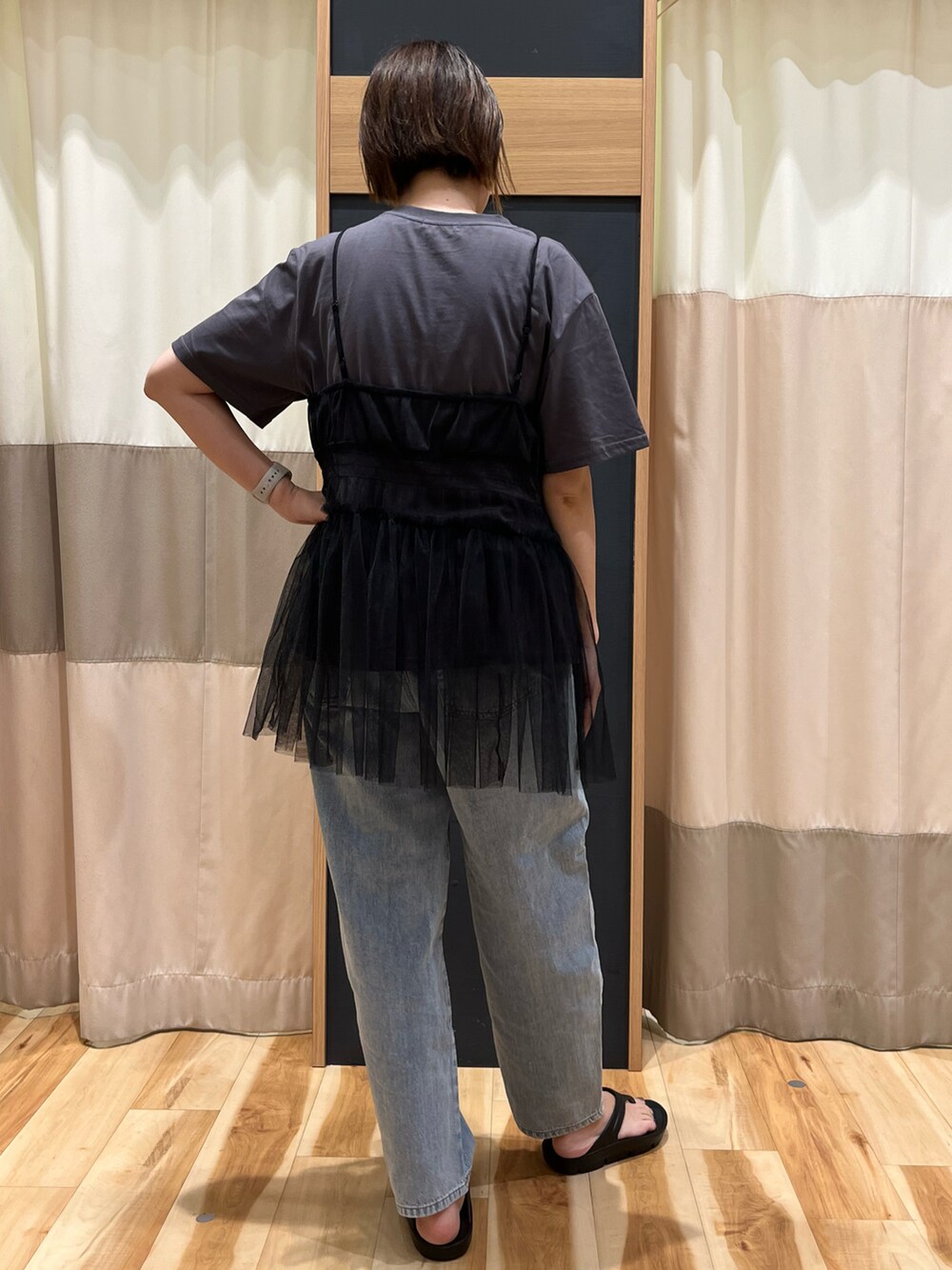 グレー系のトップス、ブルー系のデニムパンツ、シルバー系のバッグを着用したレディースの夏コーディネートの3枚目の写真