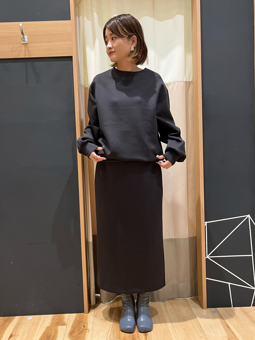 グレー系のTシャツ/カットソー、グレー系のスカートを着用したレディースの秋コーディネートの2枚目の写真