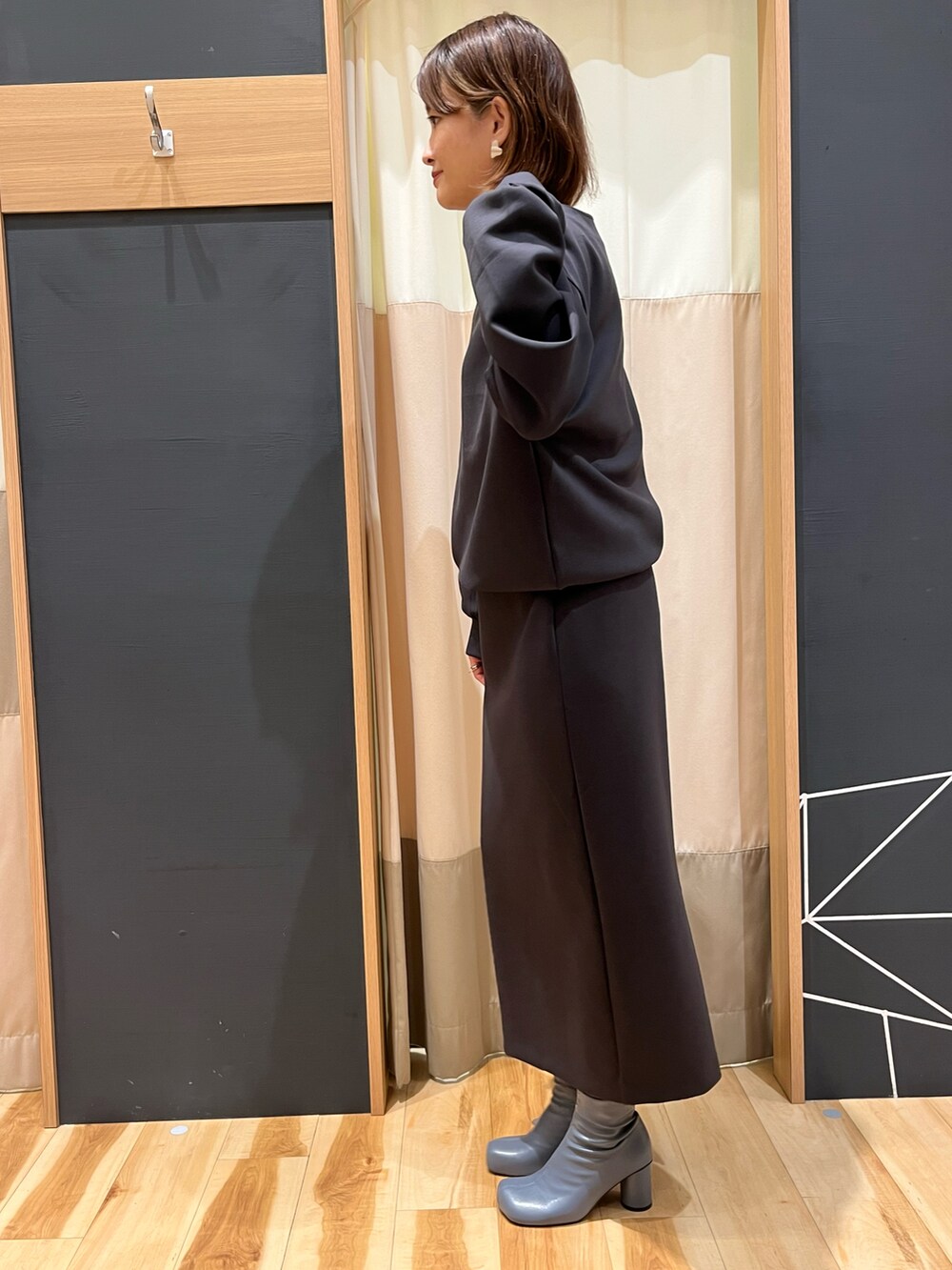 グレー系のTシャツ/カットソー、グレー系のスカートを着用したレディースの秋コーディネートの3枚目の写真