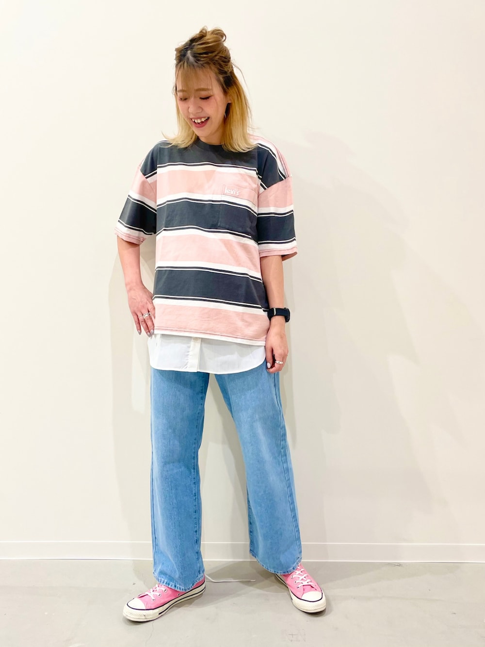 ホワイト系のタンクトップ、ピンク系のスニーカー、ブルー系のデニムパンツを着用したレディースの夏コーディネートの2枚目の写真